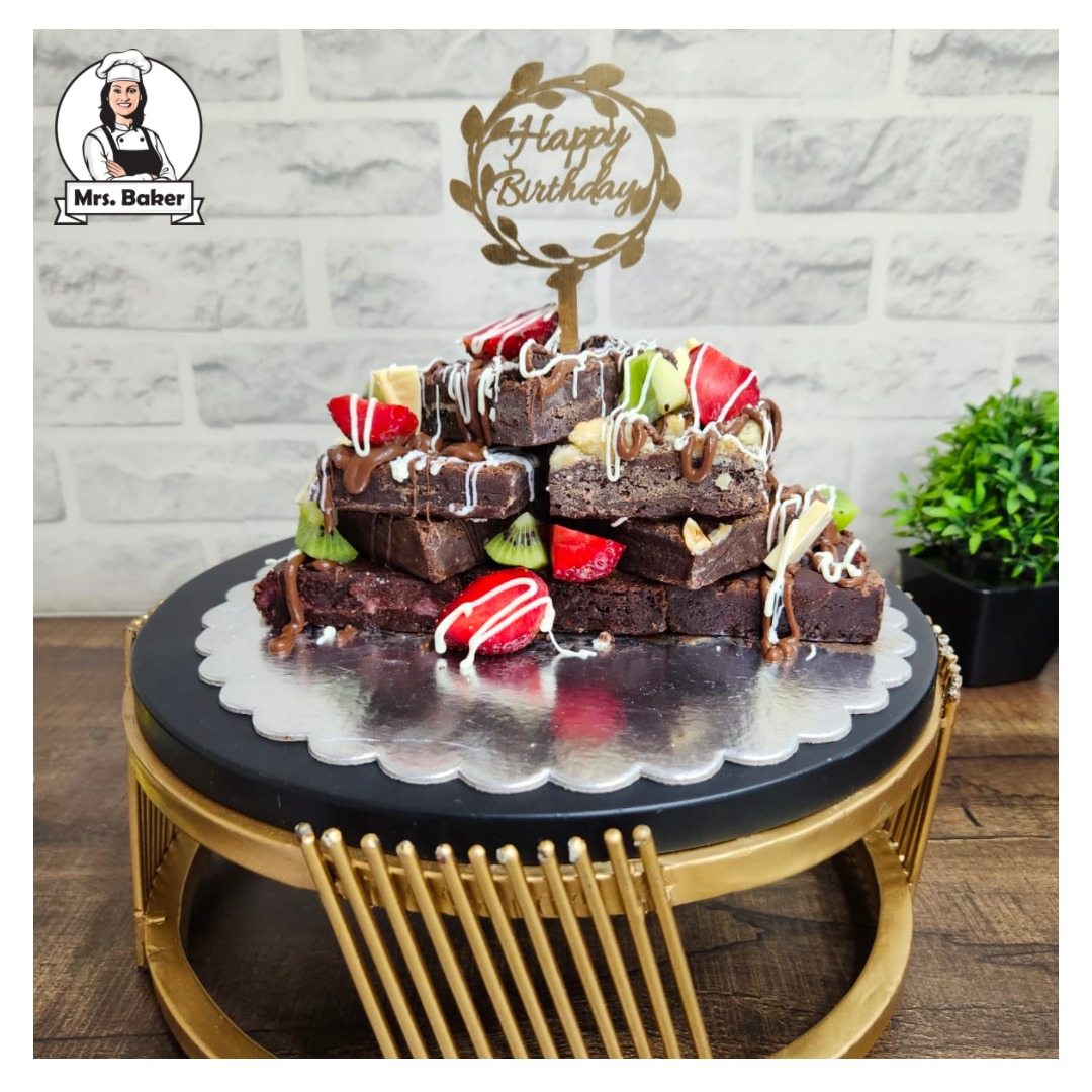 A stack of Mrs.Baker fudgy brownies topped with chocolate and fresh fruit